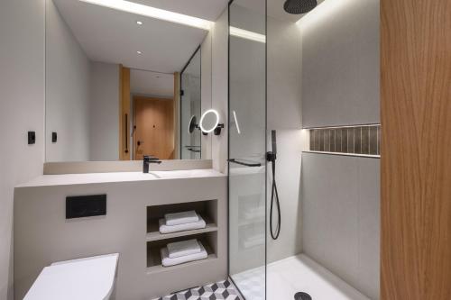 a bathroom with a shower and a sink and a mirror at Residence Inn by Marriott Lisbon in Lisbon