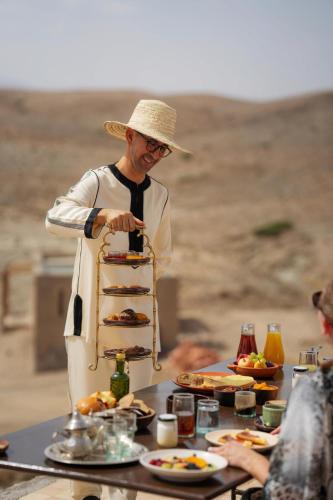 a man in a hat preparing food on a table at Nomad's Land Marrakech in El Karia