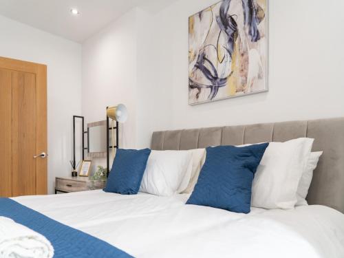 a bedroom with a bed with blue and white pillows at The Sapphire Suite - 2BR 2Bath City Centre in Leicester