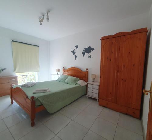 a bedroom with a bed and a wooden cabinet at Los Llanos Ocean view in Los Llanos de Aridane