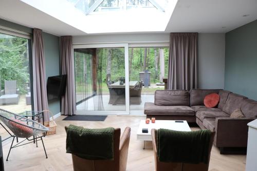 a living room with a couch and a table at Natuurhuisje Vechtdal Bungalow met privé sauna zwemmeer en houthaard in Vilsteren