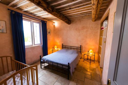 a bedroom with a bed and a window at Maison L'oustalette De Mau-bé in Maubec