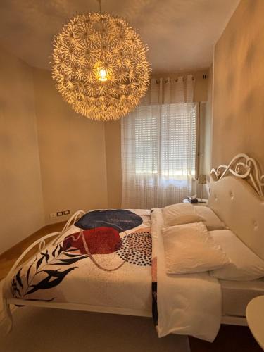 a bedroom with a bed and a chandelier at The Green Nest Perugia in Perugia