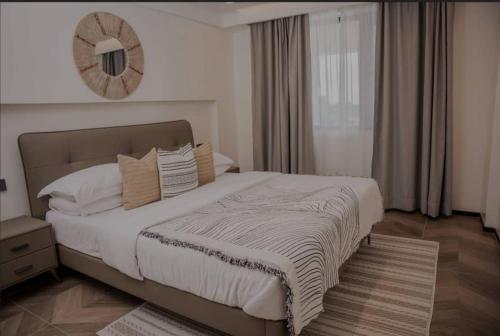 ein Schlafzimmer mit einem großen Bett und einem Spiegel an der Wand in der Unterkunft Luxury phonex Apartment in Daressalam