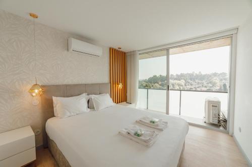 a bedroom with a large white bed with a large window at Amazing Pool Apartments by Vacationy in Vila Nova de Gaia