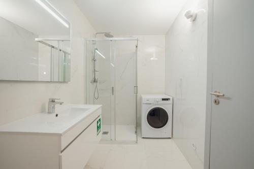 a white bathroom with a washing machine in a shower at Amazing Pool Apartments by Vacationy in Vila Nova de Gaia