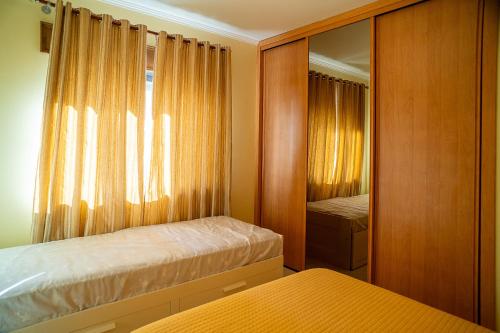 une chambre avec deux lits et un miroir dans l'établissement Vila das Conchas - Enjoy the Seaview Pool with the Beach only steps away, à Sesimbra