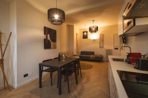 トリノにあるDomus Nova - Una finestra sui tettiのテーブルとキッチンのあるリビングルーム
