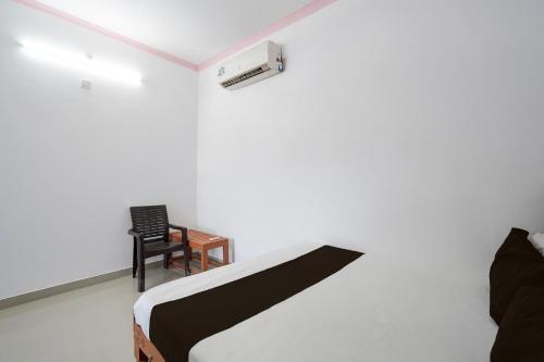 a bedroom with a bed and a table and a chair at Hotel O Mandkaranya in Misrikh