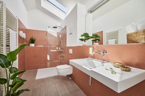 a bathroom with a sink and a shower and a toilet at SEEGER Living Premium Downtown in Karlsruhe