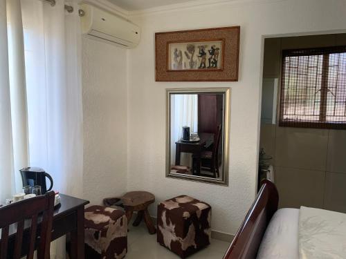 a bedroom with a bed and a mirror and a table at Xintu Xa Hina Guesthouse in Nkowakowa