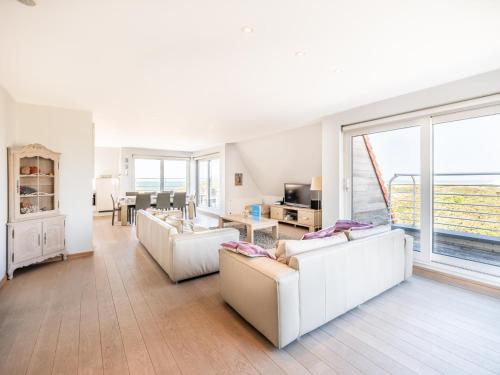 a living room with white furniture and a large window at Seawhisper in Galopen