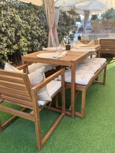 a wooden table and chairs sitting on the grass at The Retreat - Armacao de Pera, Algarve Portugal in Pêra