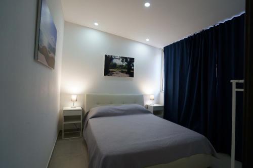 Un dormitorio pequeño con una cama y dos mesitas de noche. en Residenza Cicerone, en Agrigento