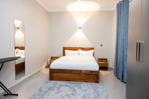 a bedroom with a bed and a mirror at Luigi Homes in Kampala