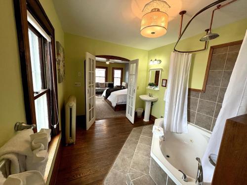 a bathroom with a bath tub and a bedroom at Inn 31 in Kingsville