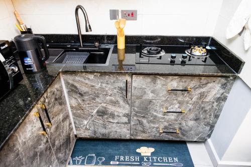 a kitchen counter with a sink and a stove at Luigi Homes in Kampala