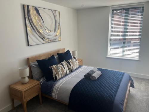 a bedroom with a bed with a blue comforter at Modern Flat in central Lichfield & secure parking in Lichfield