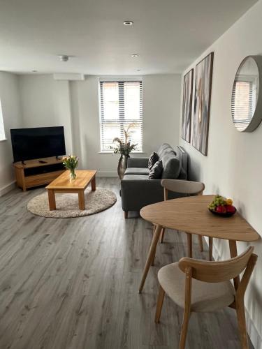 a living room with a couch and a table at Modern Flat in central Lichfield & secure parking in Lichfield