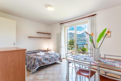 1 dormitorio con 1 cama y 1 mesa con comedor en Villaggio Turistico Priori Malcesine, en Malcesine