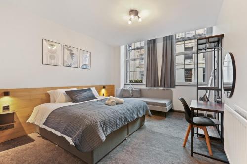 une chambre avec un lit, un bureau et une chaise dans l'établissement Clayton Apartments, à Newcastle upon Tyne