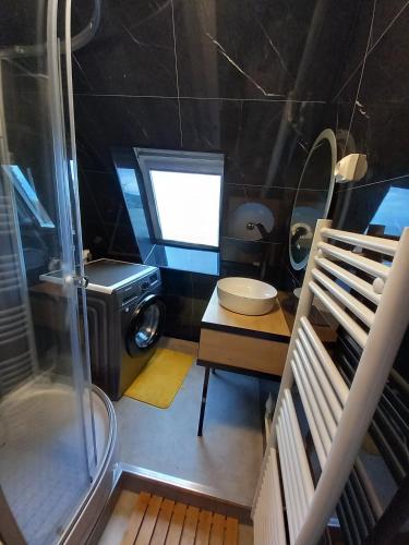 a small bathroom with a washing machine and a sink at Studio Alizée accès direct Promenade Marcel Proust in Cabourg