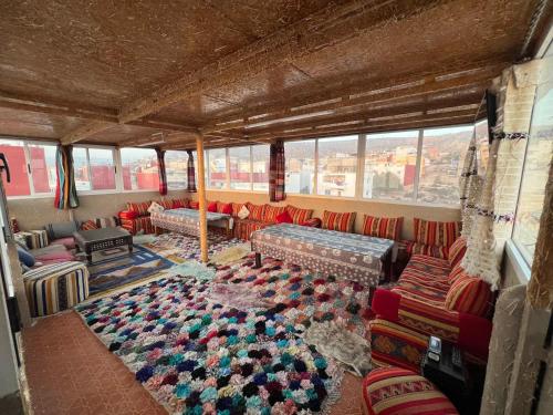 a living room with couches and a rug at Surf capitain in Tamraght Ouzdar