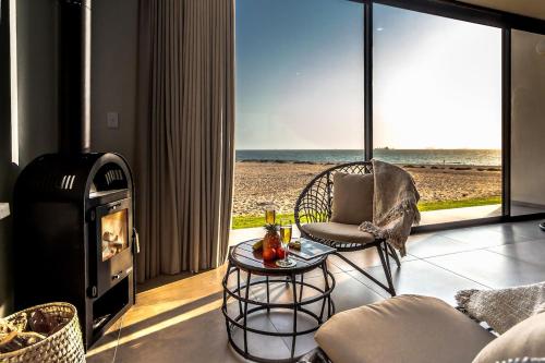 a living room with a chair and a fireplace at Dolphin View Beach House in Walvis Bay