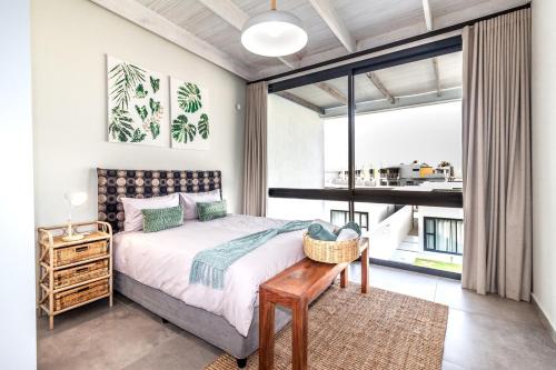 a bedroom with a bed and a large window at Dolphin View Beach House in Walvis Bay