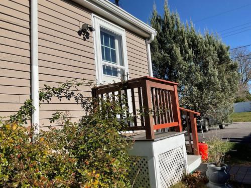 a wooden chair sitting outside of a house at Exquisite 1 Bedroom Suite Charming W Private Entry in Framingham