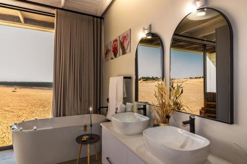 a bathroom with two sinks and a bath tub at Dolphin View Beach House in Walvis Bay