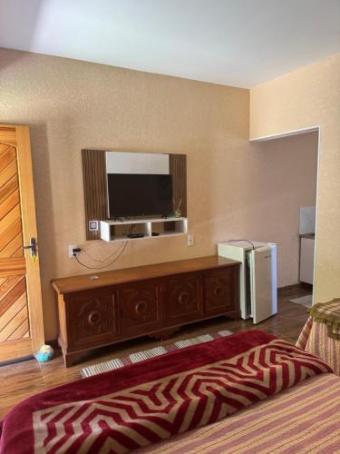 a bedroom with a television and a dresser with a dresser at Recanto das Onças in Extrema