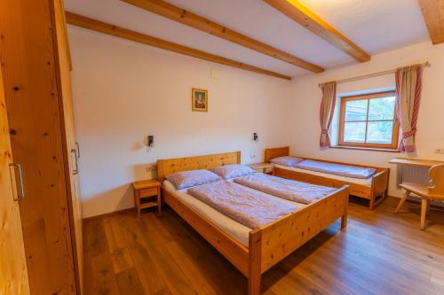 a bedroom with two beds and a table at Untergisserhof in Sesto