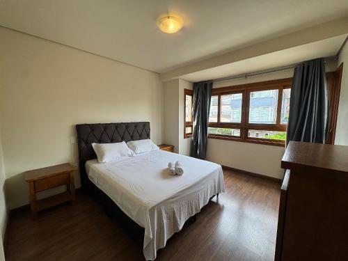 una camera da letto con un letto con due orsacchiotti sopra di Apê Novo Centro de Gramado 02 dorm a Gramado