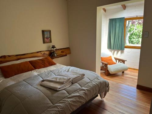 a bedroom with a bed with two towels on it at Huala Hosteria in Lago Puelo