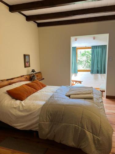 a bedroom with a large bed with blue curtains at Huala Hosteria in Lago Puelo