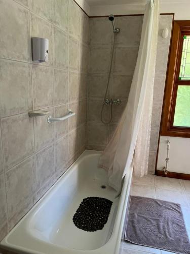 a white bath tub in a bathroom with a shower at Huala Hosteria in Lago Puelo