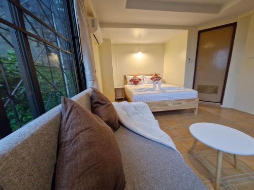 a living room with a bed and a couch at The Cozy House in Karon Beach