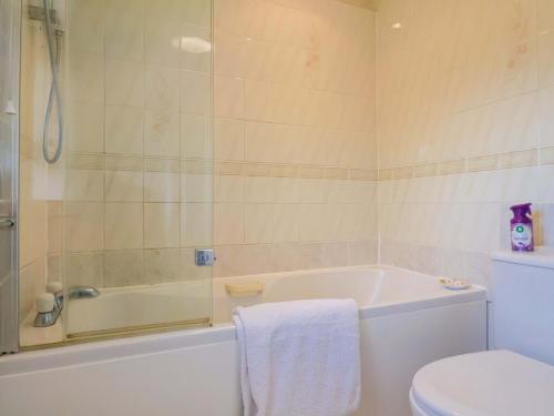 a bathroom with a tub and a toilet and a sink at Poppy Cottage in Charlton Marshall
