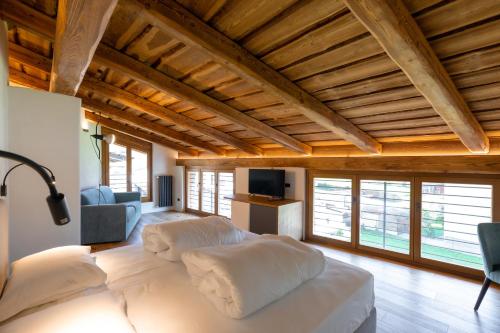 ein großes Bett in einem Zimmer mit Holzdecken in der Unterkunft La Corte del Glicine in Villa di Tirano