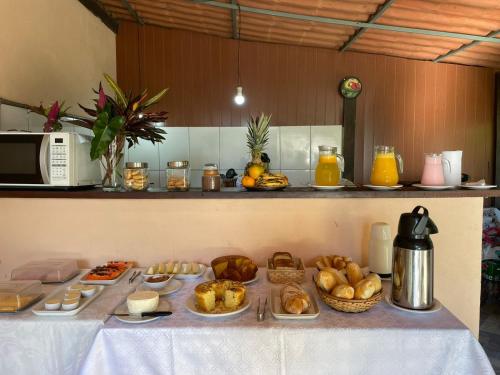 a table with bread and pastries on it in a kitchen at Pousada Luar da Serra Lumiar in Nova Friburgo