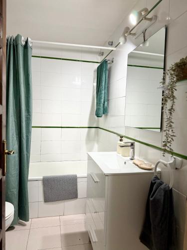 a bathroom with a tub and a sink and a mirror at Apartamento 1 con Piscina en Llança in Llança