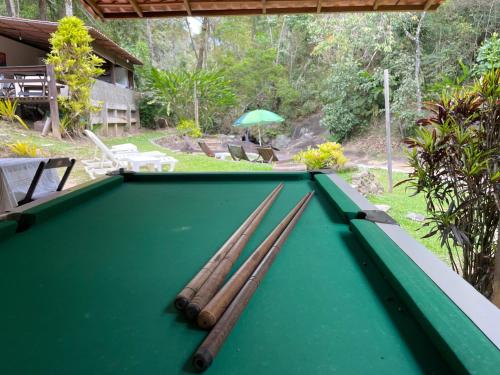 a pool table with four cue sticks on it at Pousada Luar da Serra Lumiar in Nova Friburgo