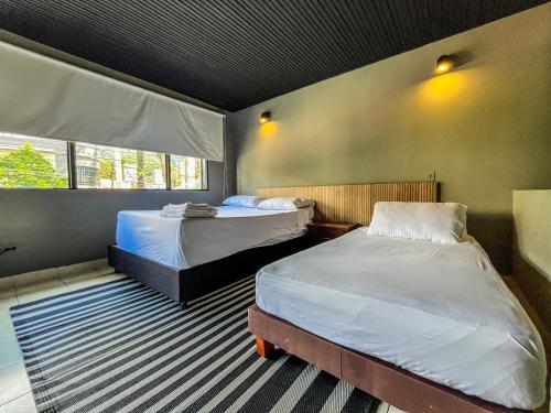 a bedroom with two beds and a window at Antonia Poolside Autonomy Hotel in Ibagué