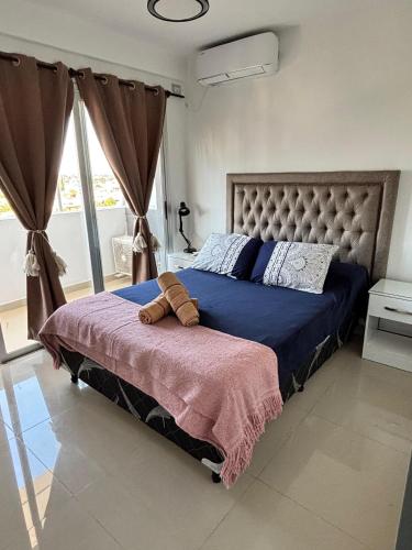 een slaapkamer met een bed met een blauw dekbed bij Dpto Bambú in Salta