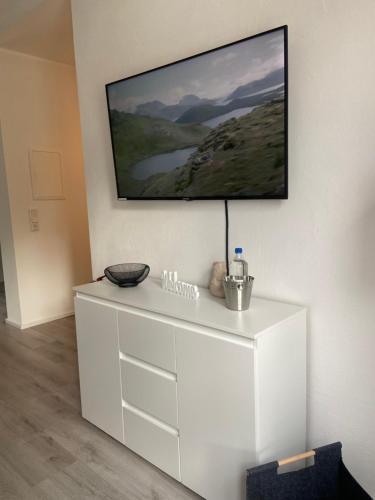 a white dresser with a flat screen tv on a wall at FeWo Seeperle in Diemelsee