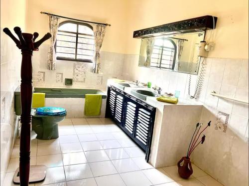 a bathroom with a tub and a sink and a toilet at Paradise Garden watamu in Watamu