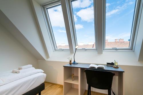 una camera da letto con scrivania e 2 finestre di Vienna Residence, Prater - Exhibition Center a Vienna