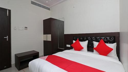 a bedroom with a large bed with red pillows at Hotel Darshan Inn in Prayagraj