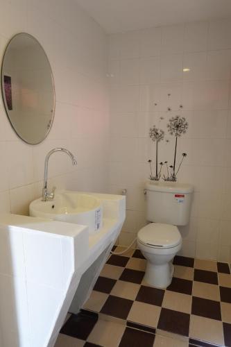 a bathroom with a sink and a toilet and a mirror at The Cozy House in Karon Beach